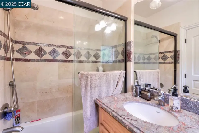 a bathroom with a granite countertop sink a mirror and a bathtub
