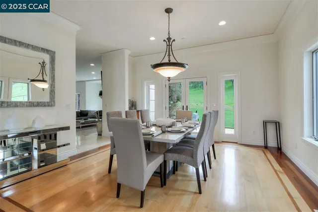 a dining room with furniture a chandelier and wooden floor