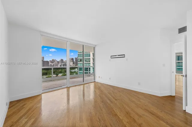 a view of a room with wooden floor and a window