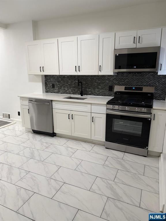 20 Maple Street Ridgefield Park, NJ 07660 - Photo 13 of 22 a kitchen with stainless steel appliances granite countertop a stove a sink and a white cabinets