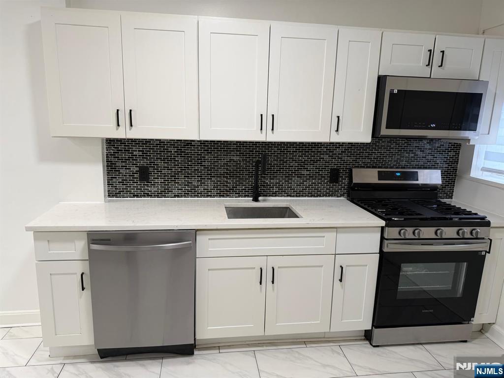 20 Maple Street Ridgefield Park, NJ 07660 - Photo 6 of 22 a kitchen with a stove and a microwave