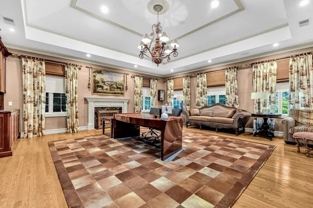 a living room with furniture a fireplace and large windows