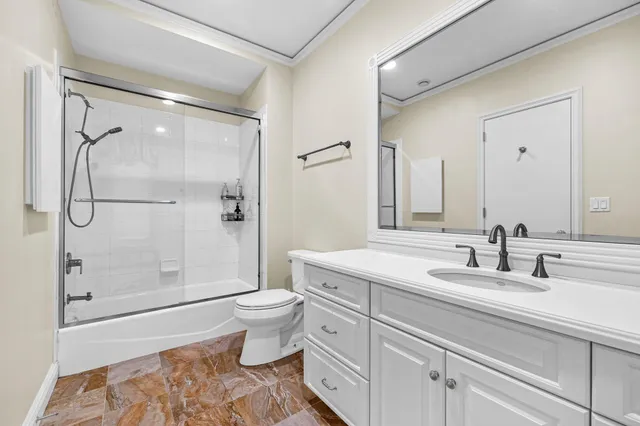 a bathroom with a granite countertop sink toilet and shower