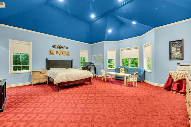 a bedroom with a bed a rug and a window