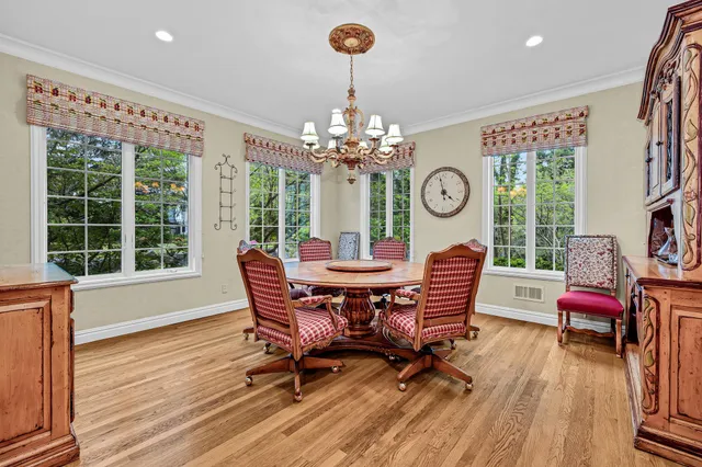 a dining room with furniture a large window and wooden floor