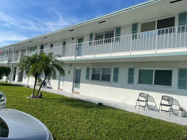 a view of swimming pool with outdoor seating and buildings in the background