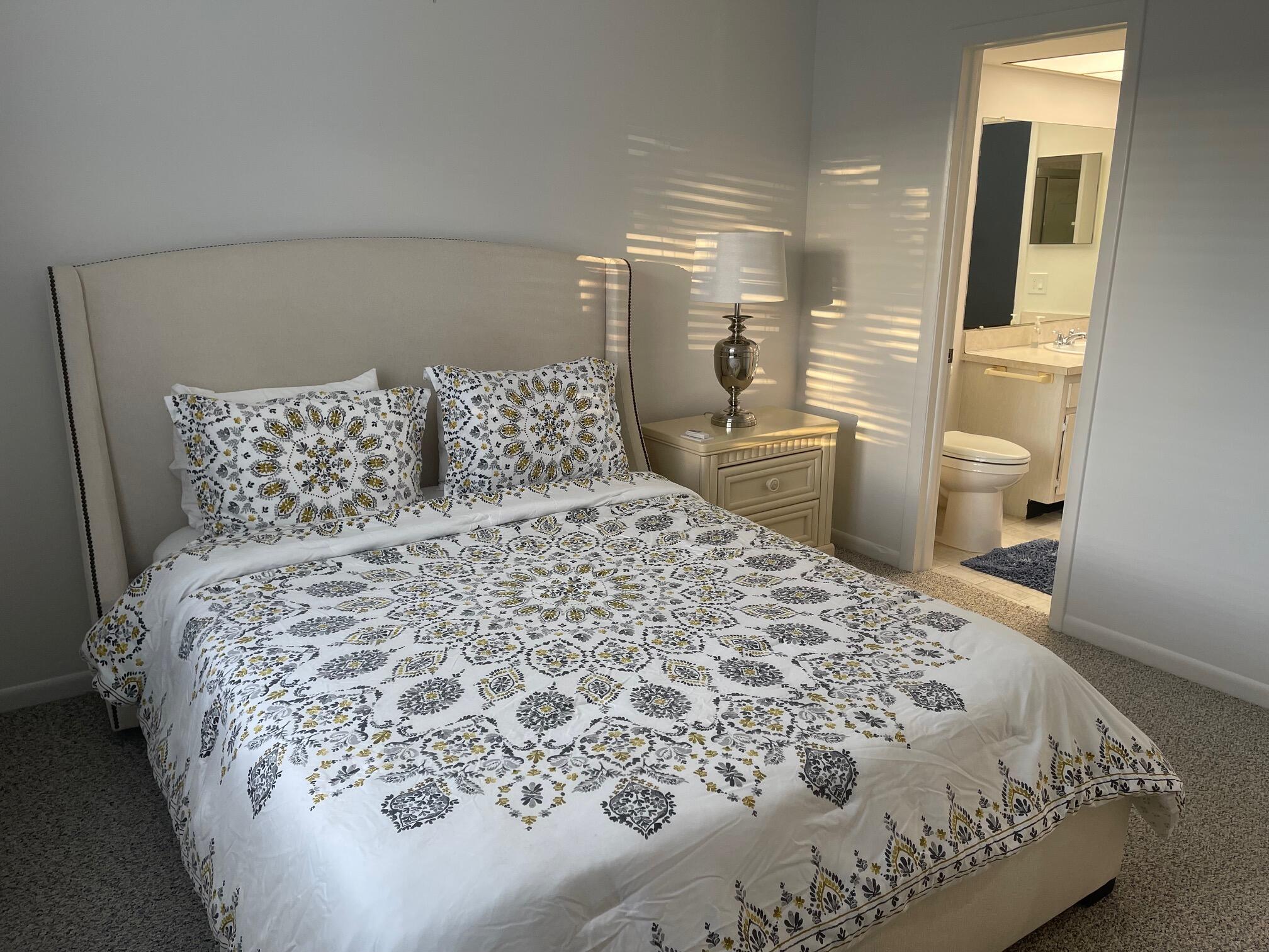 117 Lake Terrace, Unit F208 Boynton Beach, FL 33426 - Photo 16 of 30 a large bed sitting in a bedroom next to a window