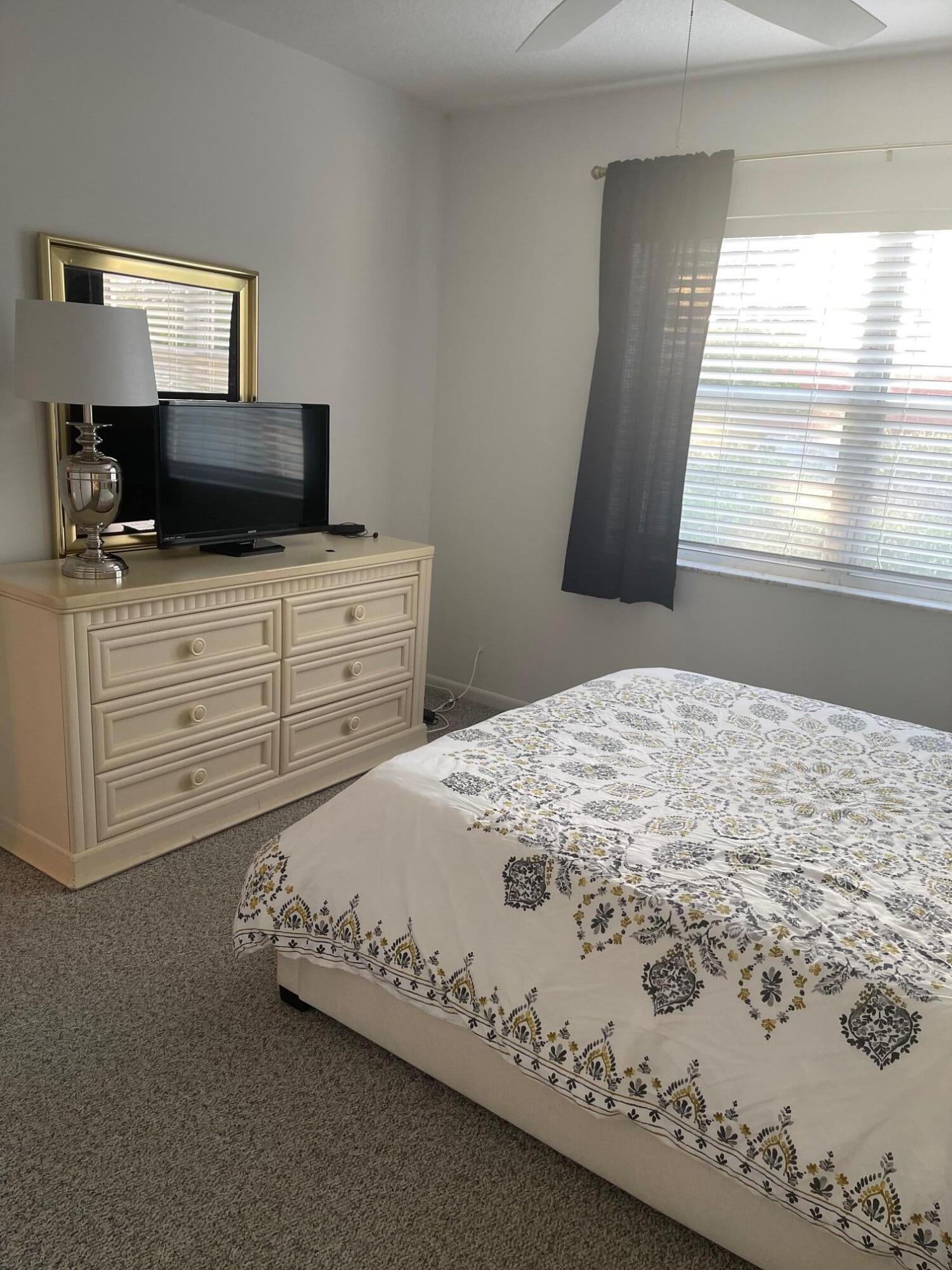 117 Lake Terrace, Unit F208 Boynton Beach, FL 33426 - Photo 17 of 30 a bedroom with a bed and a window