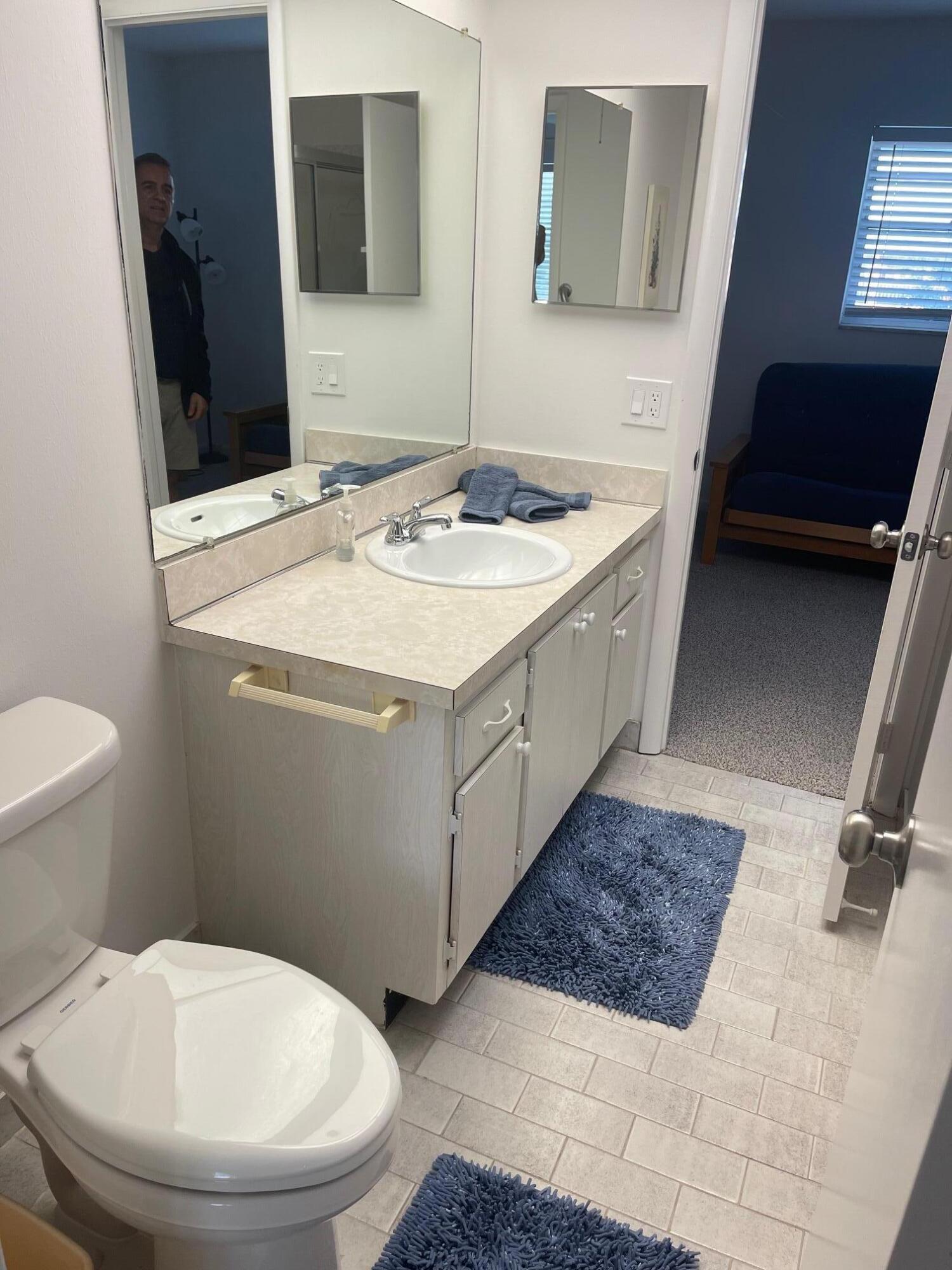 117 Lake Terrace, Unit F208 Boynton Beach, FL 33426 - Photo 20 of 30 a bathroom with a sink a toilet and mirror