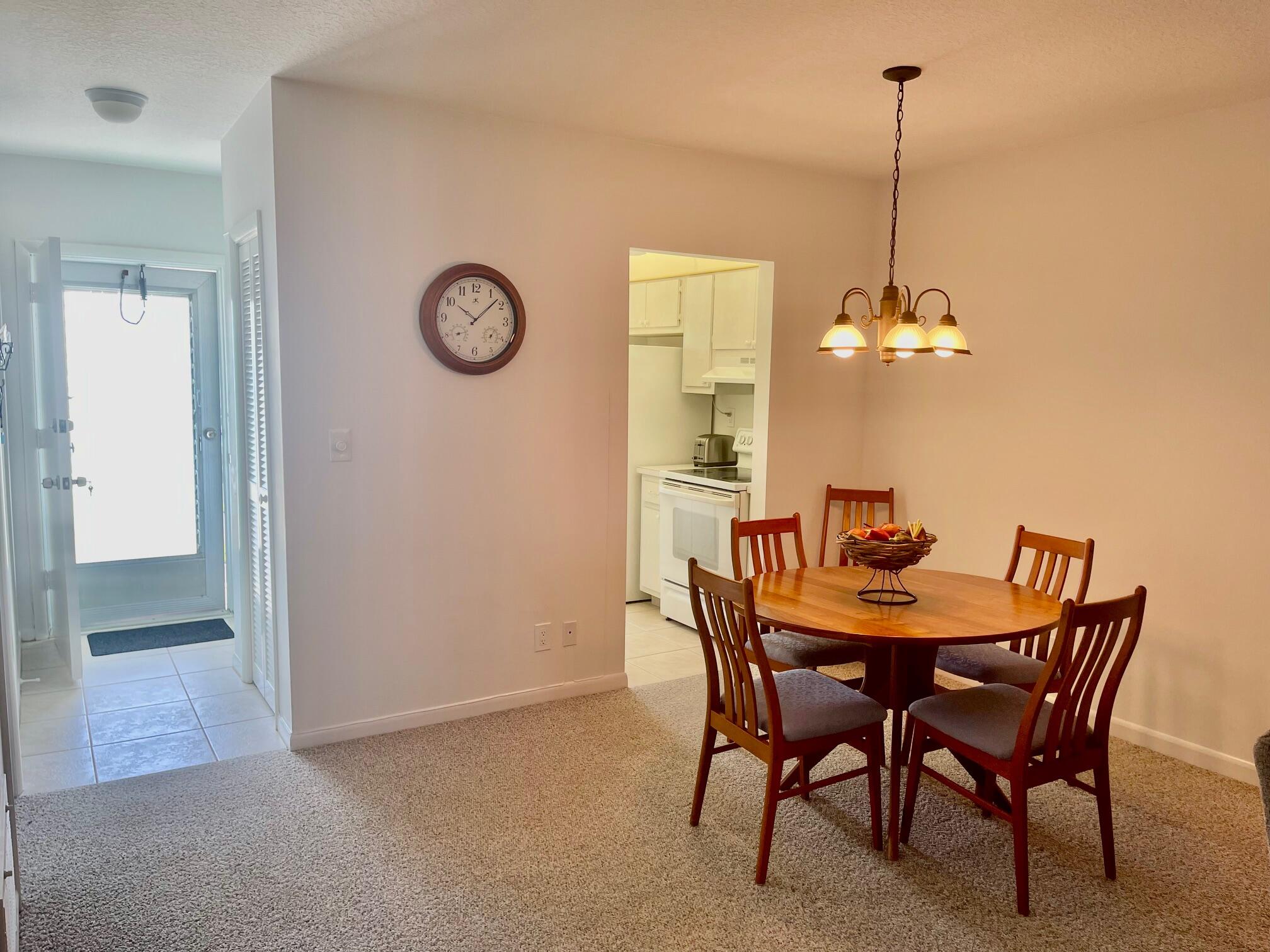 117 Lake Terrace, Unit F208 Boynton Beach, FL 33426 - Photo 6 of 30 a view of a dining room with furniture and chandelier