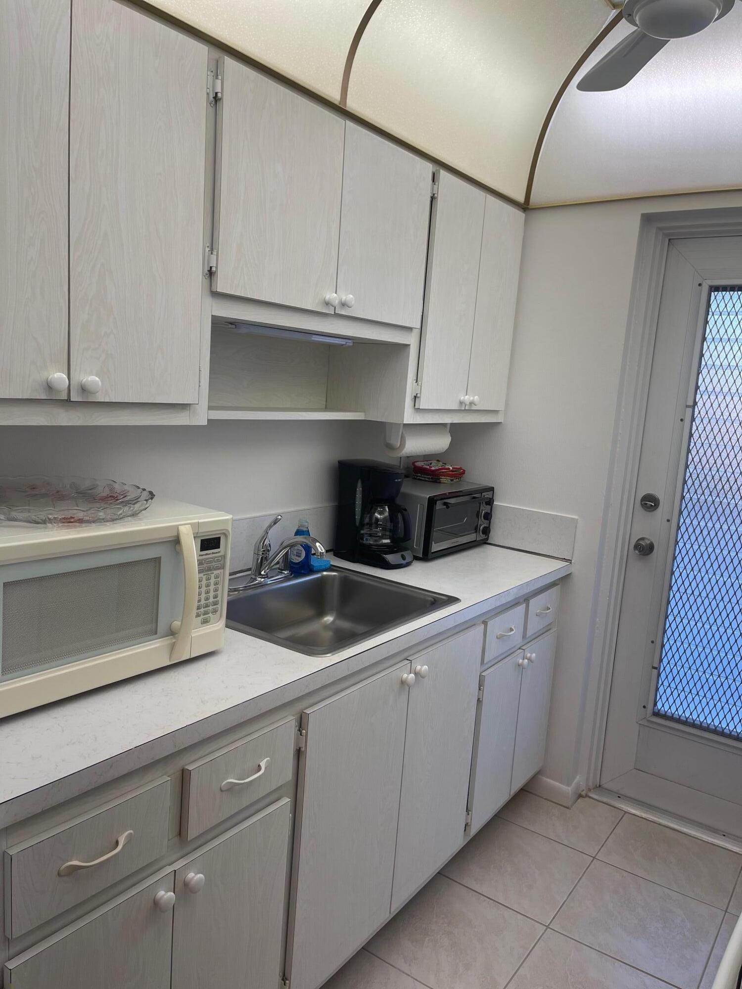 117 Lake Terrace, Unit F208 Boynton Beach, FL 33426 - Photo 10 of 30 a kitchen with stainless steel appliances granite countertop a sink and cabinets
