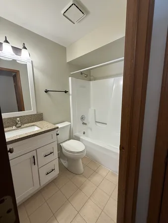 a bathroom with a double vanity sink mirror and toilet
