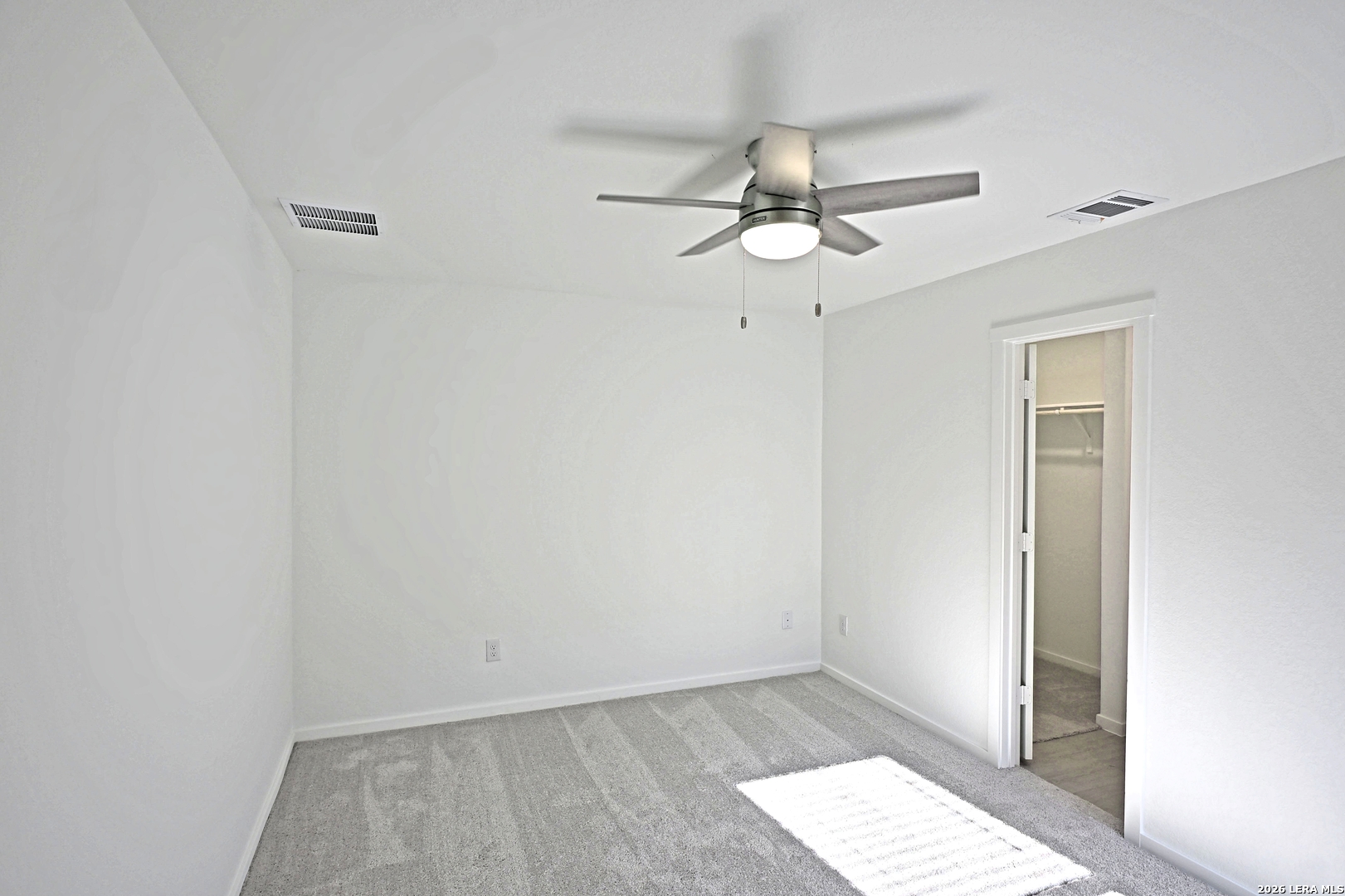 6730 Marble Ridge Elmendorf, TX 78112 - Photo 13 of 17 an empty room with wooden floor fan and windows