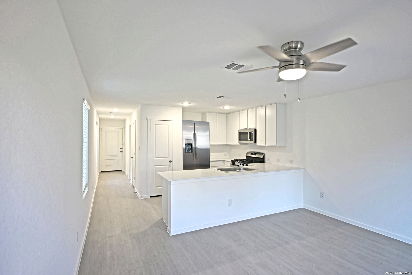 6730 Marble Ridge Elmendorf, TX 78112 - Photo 7 of 17 a kitchen with stainless steel appliances a sink a stove a refrigerator cabinets and a dining table