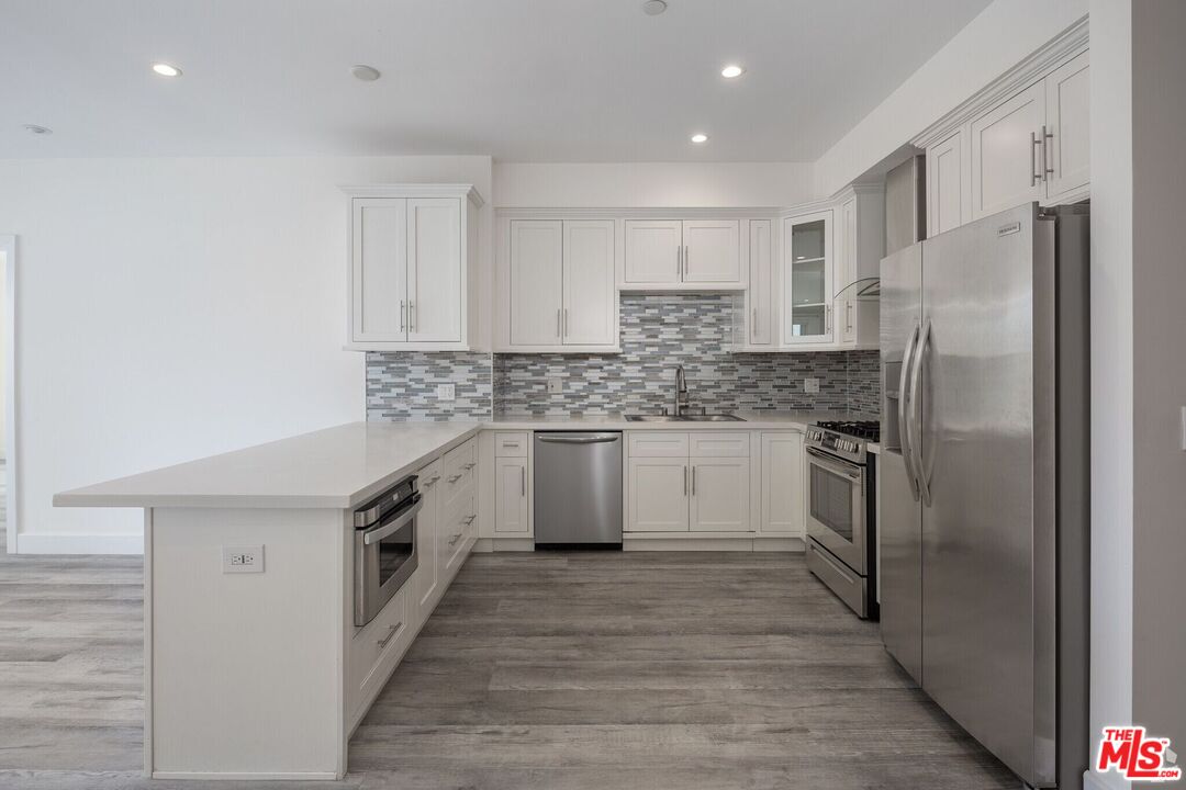 1237 South Holt Avenue, Unit 205 Los Angeles, CA 90035 - Photo 14 of 29 a kitchen with a refrigerator sink and cabinets