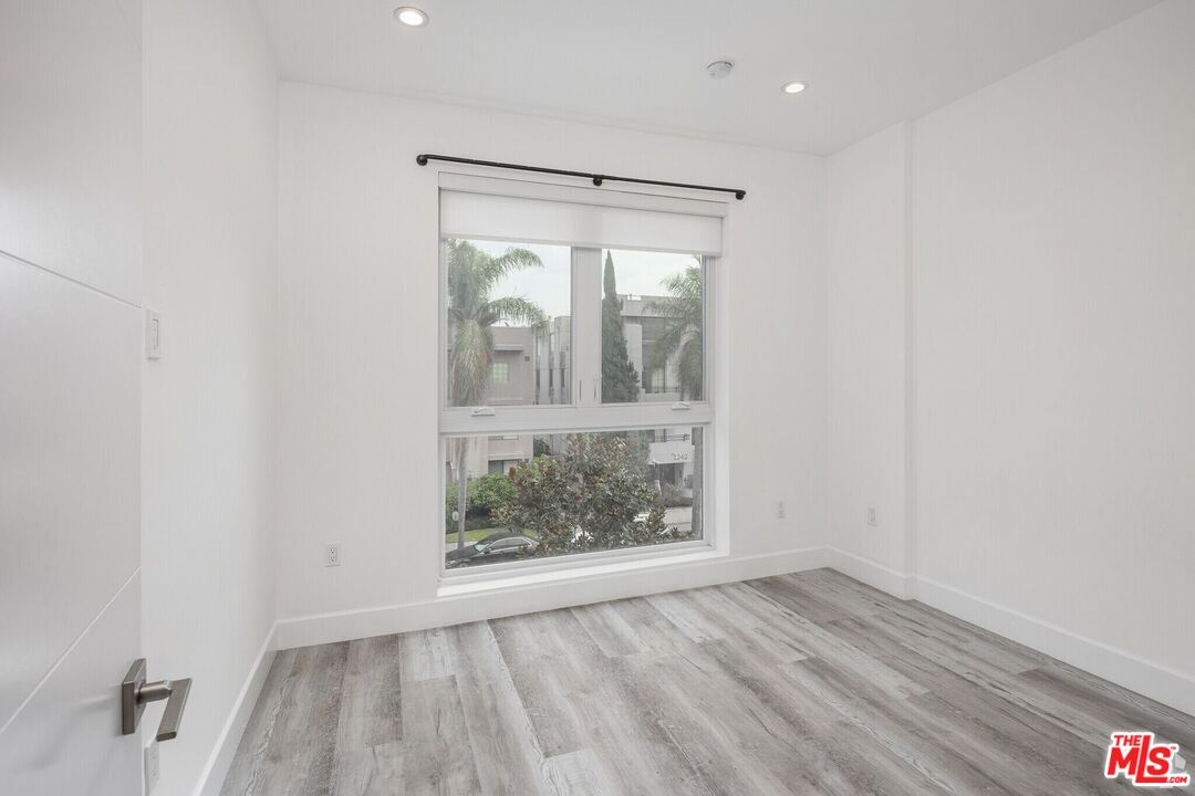 1237 South Holt Avenue, Unit 205 Los Angeles, CA 90035 - Photo 23 of 29 wooden floor in an empty room with a window