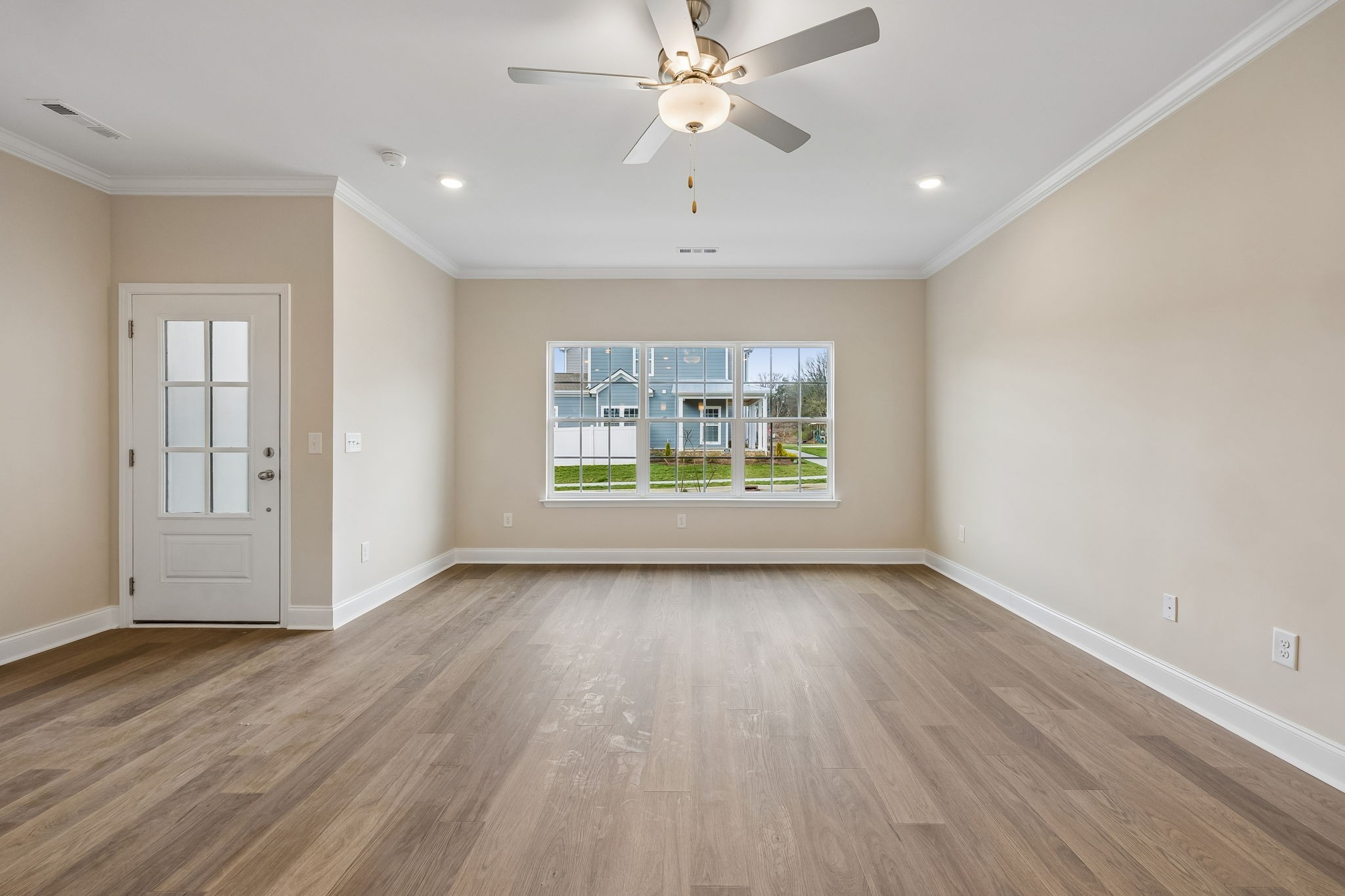 3215 Tasker Drive Antioch, TN 37013 - Photo 10 of 53 an empty room with wooden floor chandelier fan and windows