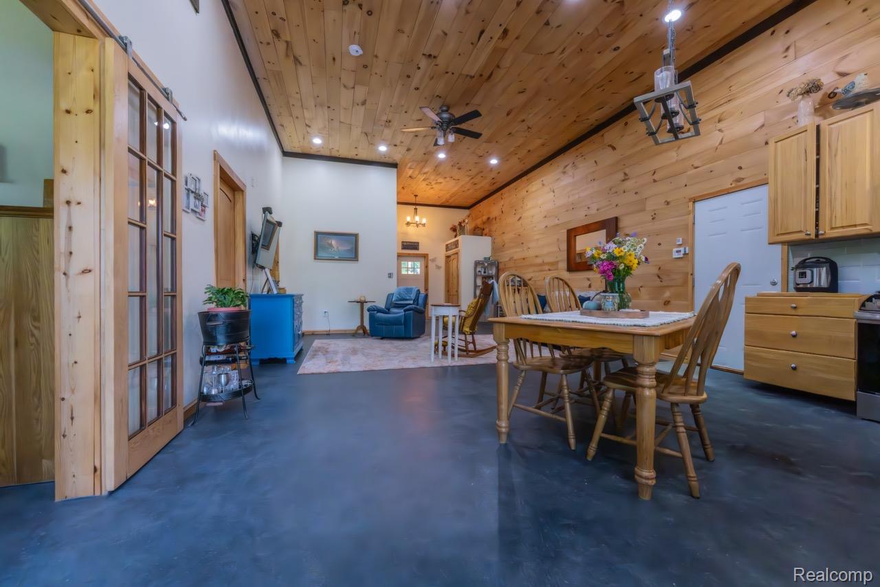 2418 South 41st Road South Cadillac, MI 49601 - Photo 13 of 57 Vaulted wood-paneled ceiling with recessed lighting, exposed wood-plank walls, dark-finish flooring, and wood cabinetry