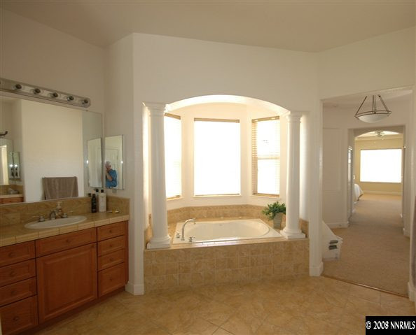 6983 Peacepipe Court Reno, NV 89511 - Photo 5 of 7 a spacious bathroom with a tub sink and mirror