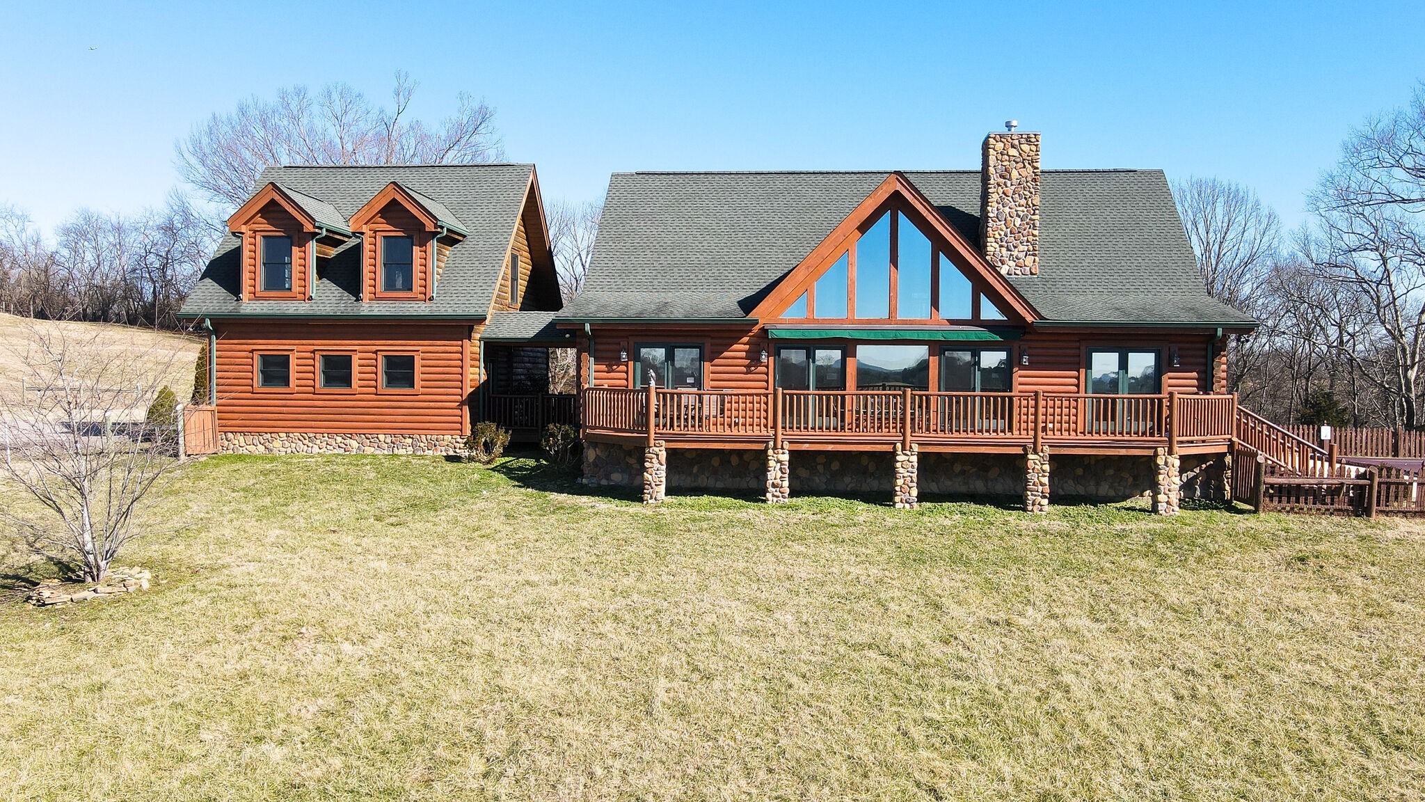 a view of a big house with large trees and plants