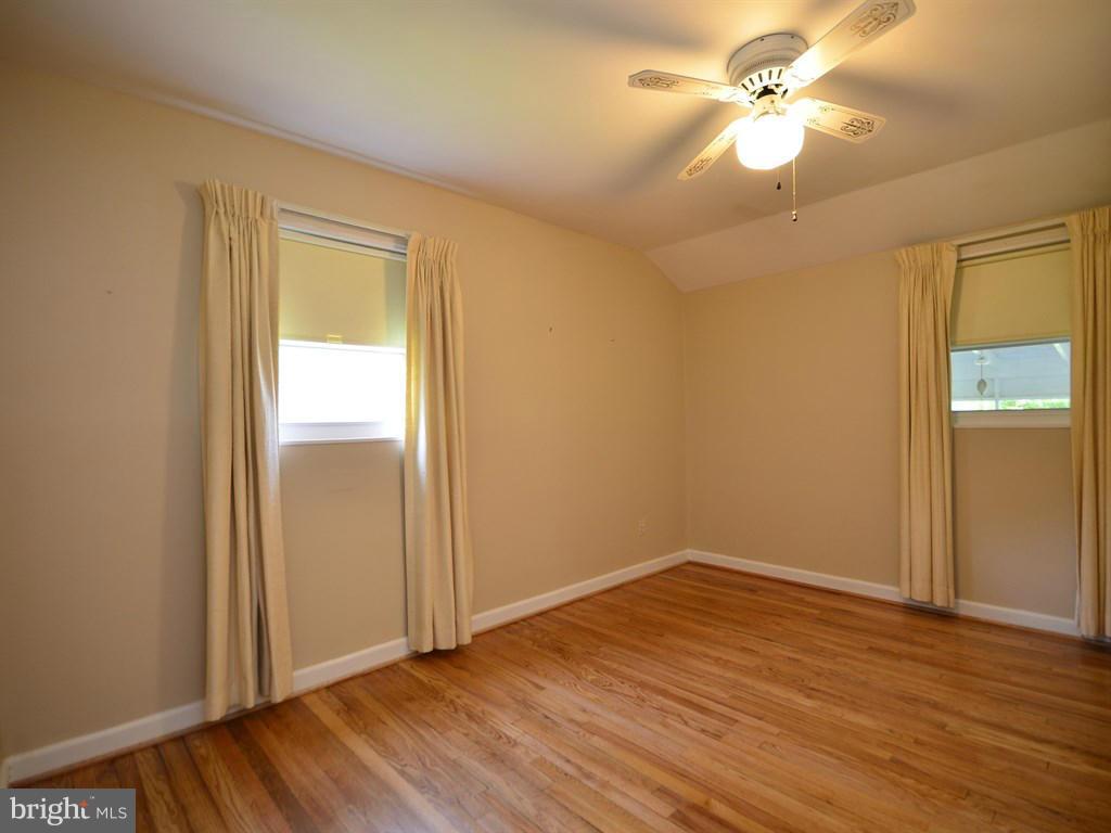 12833 Flack Street Silver Spring, MD 20906 - Photo 14 of 30 an empty room with wooden floor fan and windows