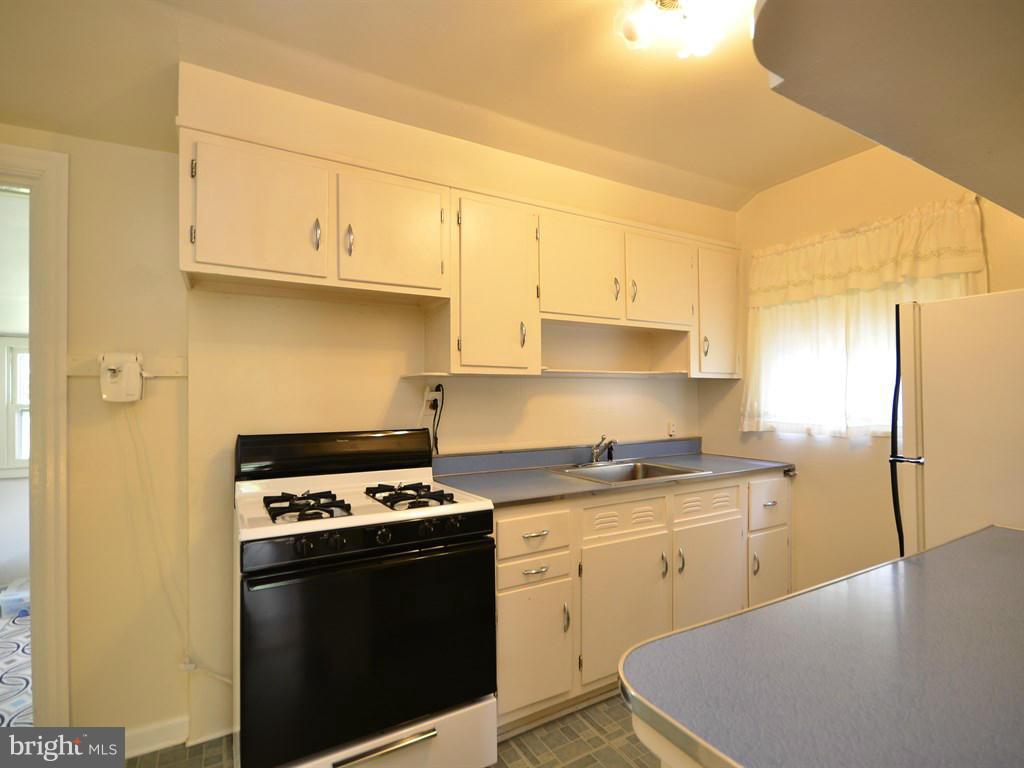 12833 Flack Street Silver Spring, MD 20906 - Photo 7 of 30 a kitchen with stainless steel appliances granite countertop a sink stove and refrigerator