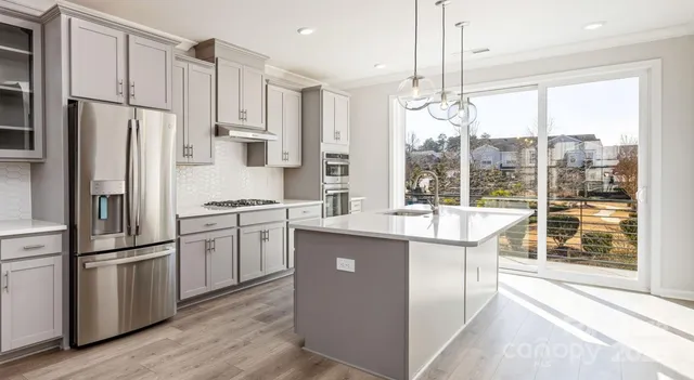 a kitchen with kitchen island wooden floor center island and stainless steel appliances
