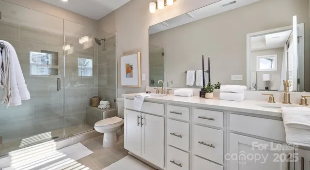 a bathroom with a double vanity sink toilet and shower