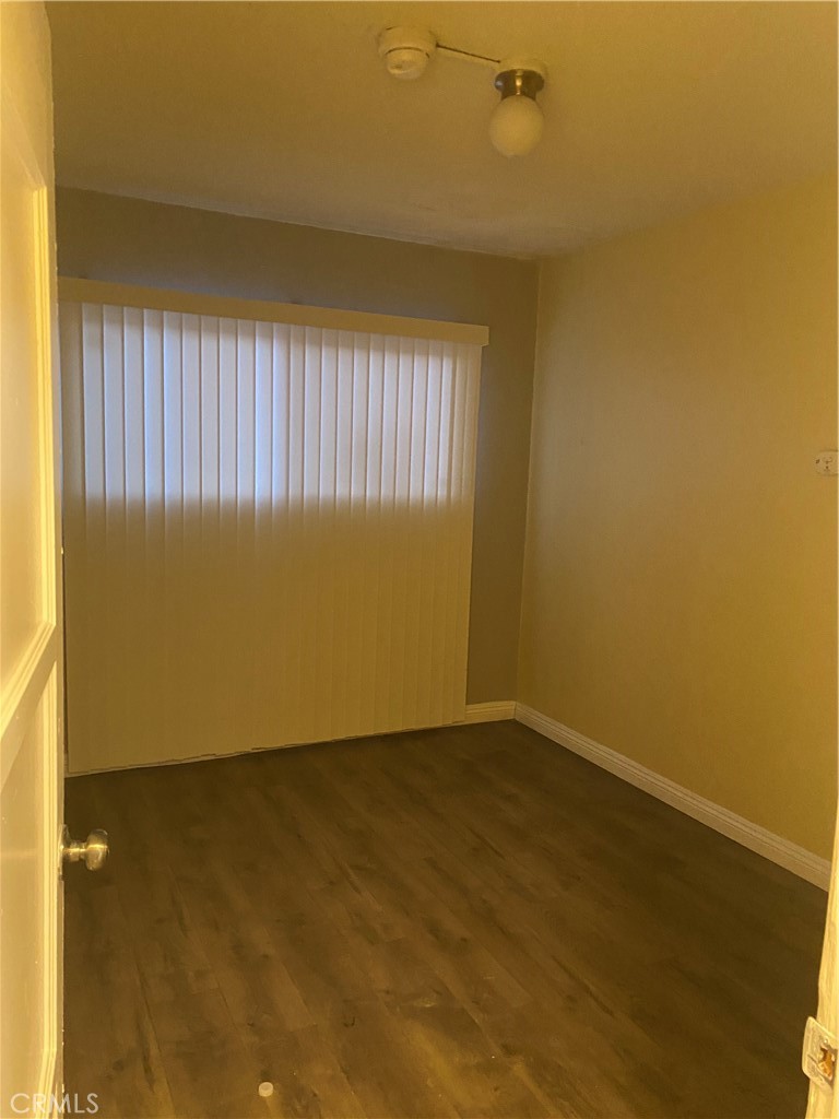 1127 Wilmington Boulevard Wilmington, CA 90744 - Photo 2 of 3 an empty room with wooden floor and windows