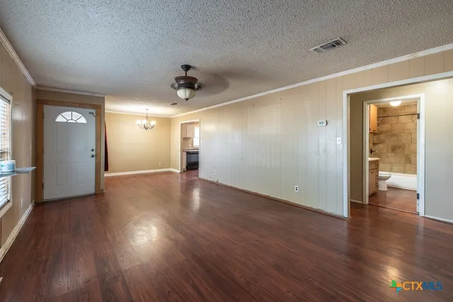a view of a hallway with wooden floor and kitchen