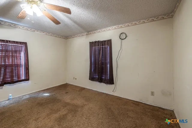 a view of a room with window and chandelier fan