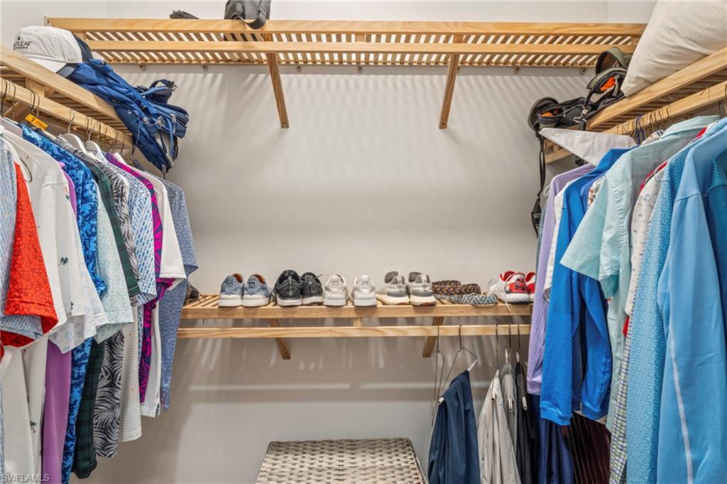 8795 Calypso Court Naples, FL 34113 - Photo 22 of 49 a view of walk in closet with clothes and shoes