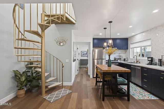 a kitchen with stainless steel appliances granite countertop a refrigerator dining table and chairs