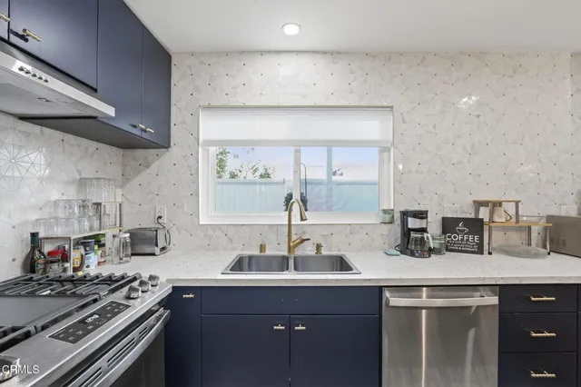 a kitchen with stainless steel appliances a sink stove and cabinets