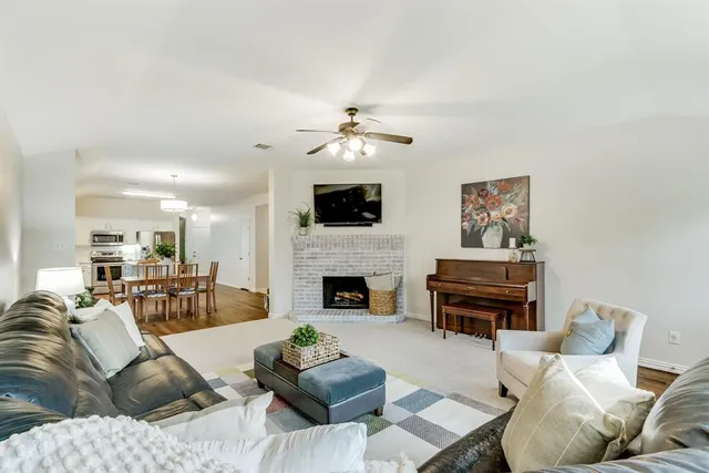 a living room with furniture a fireplace and a flat screen tv