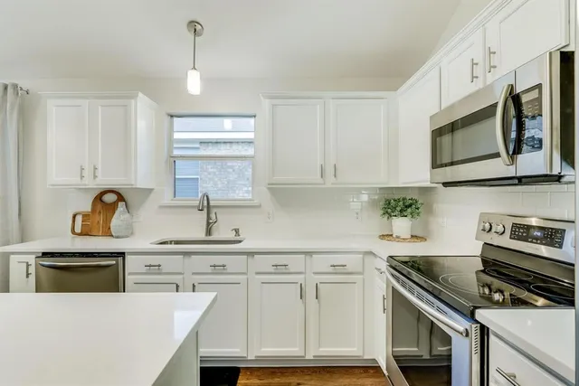 a kitchen with cabinets stainless steel appliances and a sink