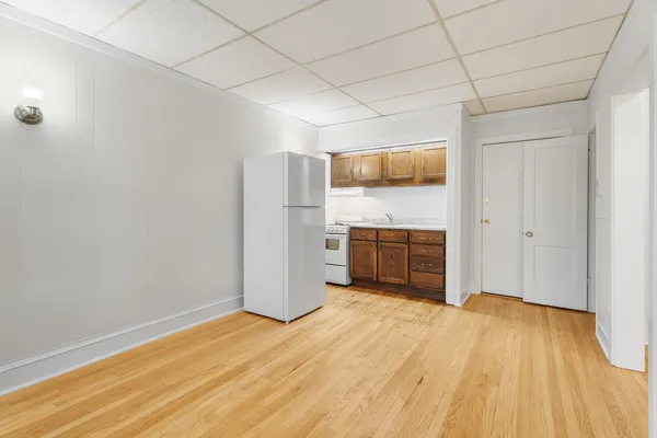 a kitchen with a wooden floor and cabinets