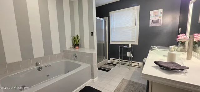 a bathroom with a tub sink and mirror