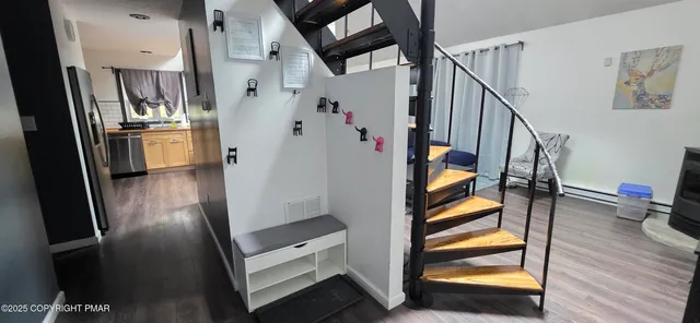 a view of hallway with stairs and wooden floor