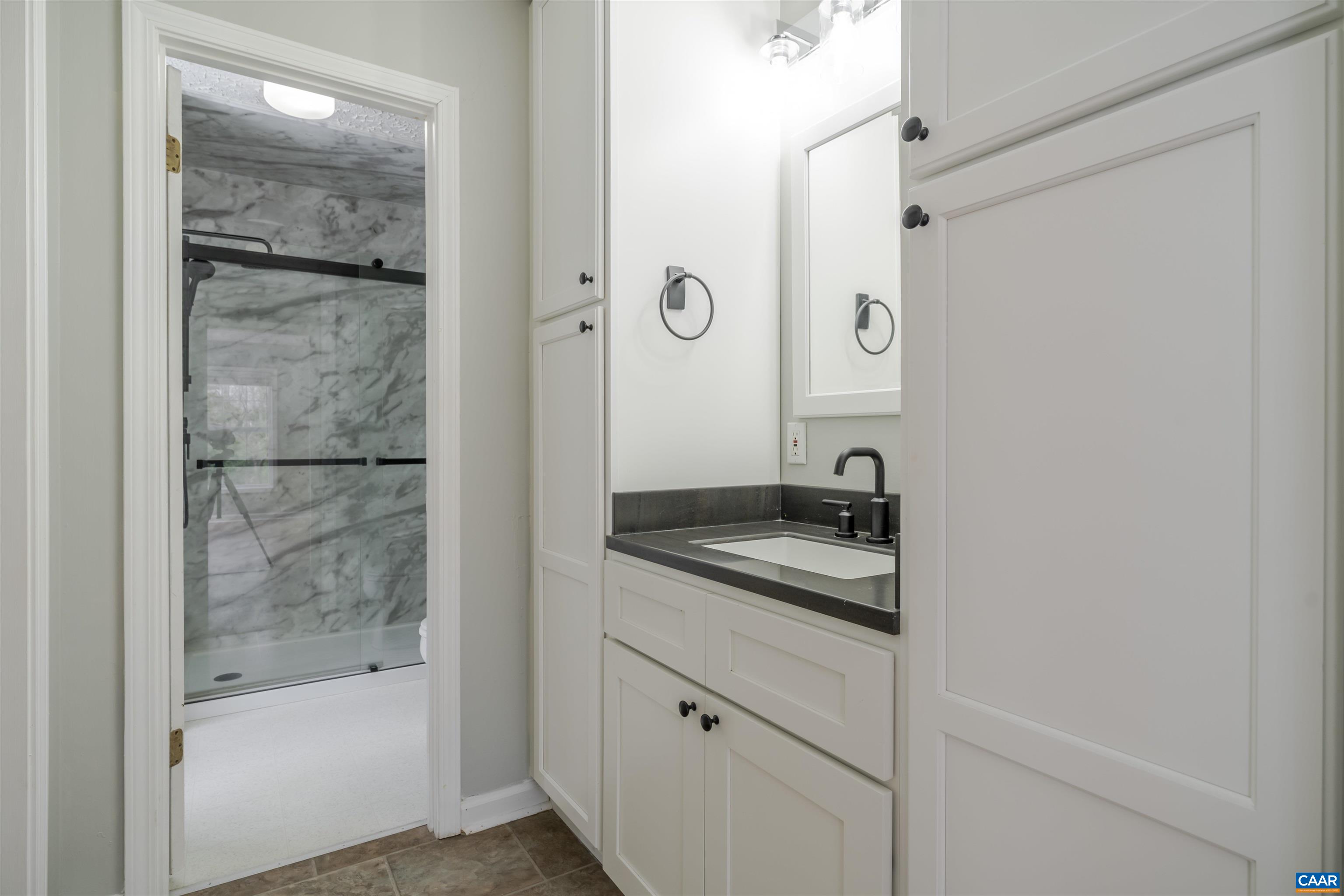 5860 Bearwood Road Crozet, VA 22932 - Photo 34 of 67 a bathroom with a granite countertop sink a mirror and shower