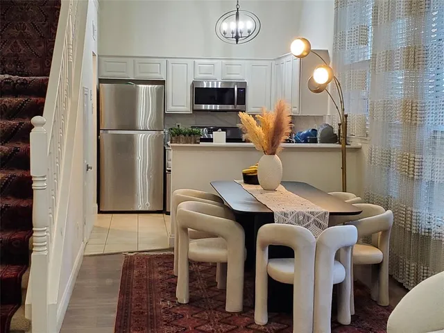 a kitchen with stainless steel appliances granite countertop a table chairs and a refrigerator