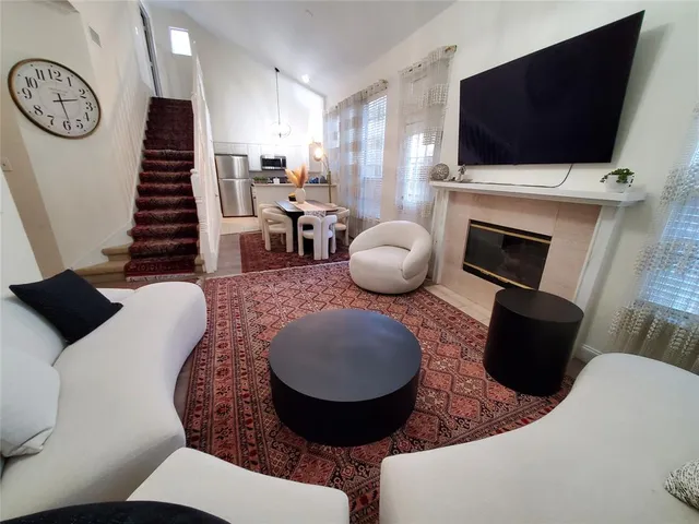 a living room with furniture a flat screen tv and a fireplace