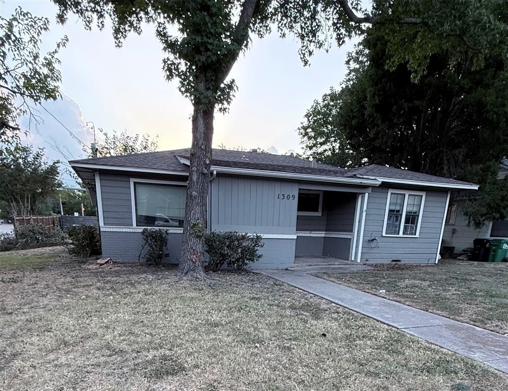 View of front of home with a front lawn and a shingled roof