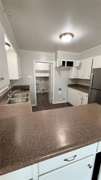 1309 Anna Street Denton, TX 76201 - Photo 5 of 13 Kitchen with white cabinetry, dark countertops, freestanding refrigerator, and dark wood-type flooring