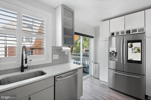a kitchen with stainless steel appliances a refrigerator sink and cabinets