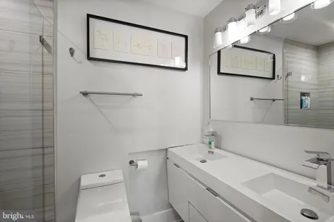 a bathroom with a sink a toilet and mirror