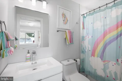 a bathroom with a sink toilet and a mirror