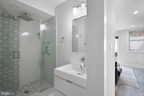 a bathroom with a sink a toilet and shower