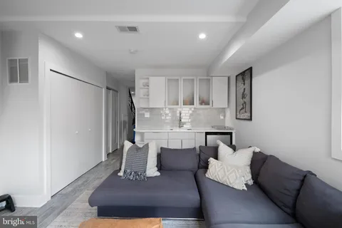 a living room with furniture and a dining table with wooden floor