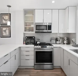 a kitchen with white cabinets stainless steel appliances and sink